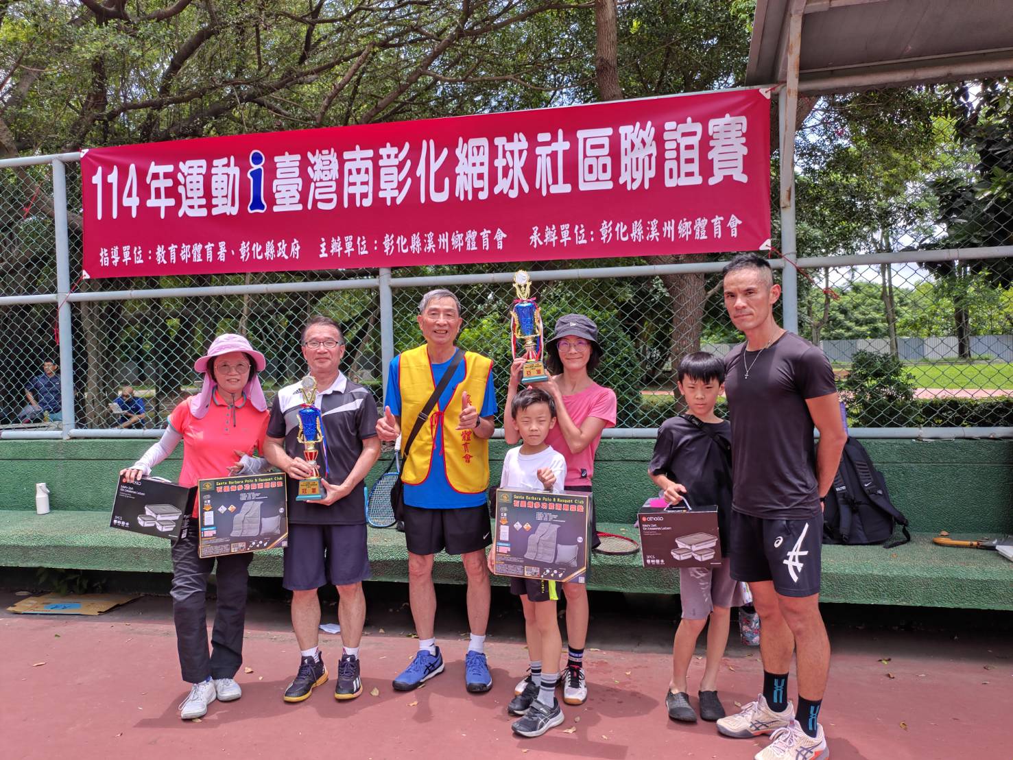 蔡政杰老師和師母在活動場地中於活動布條前一同合照
